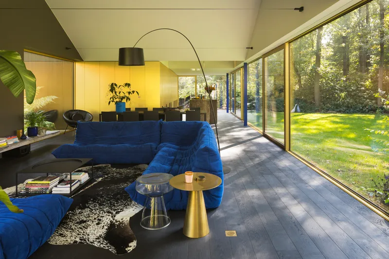 Living room with dark timber floor and sliding glass doors opening to sunlit garden