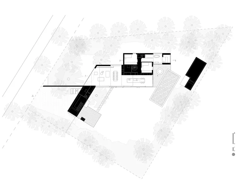 Site plan drawing showing angled building volumes arranged around a courtyard with surrounding tree canopy