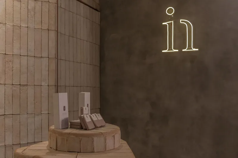 Neon numeral signage on concrete wall beside circular platform with dispensers and towels