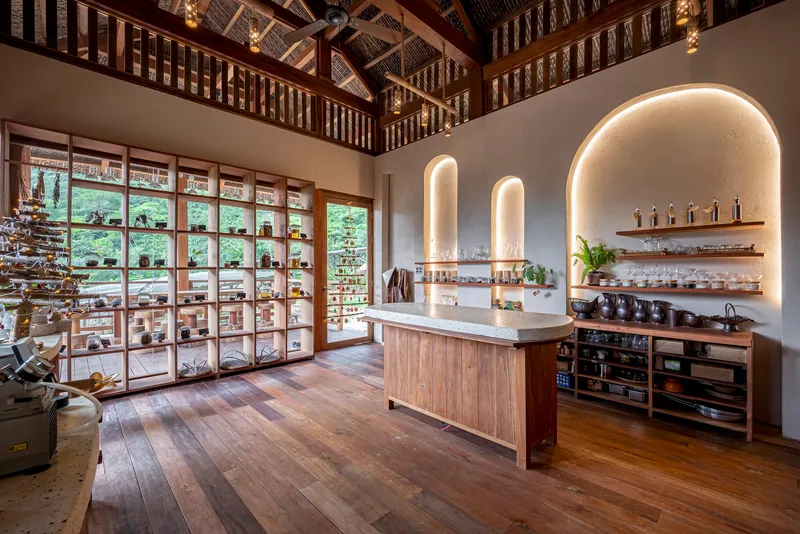 Double-height kitchen with arched alcove illuminated by concealed lighting under woven ceiling