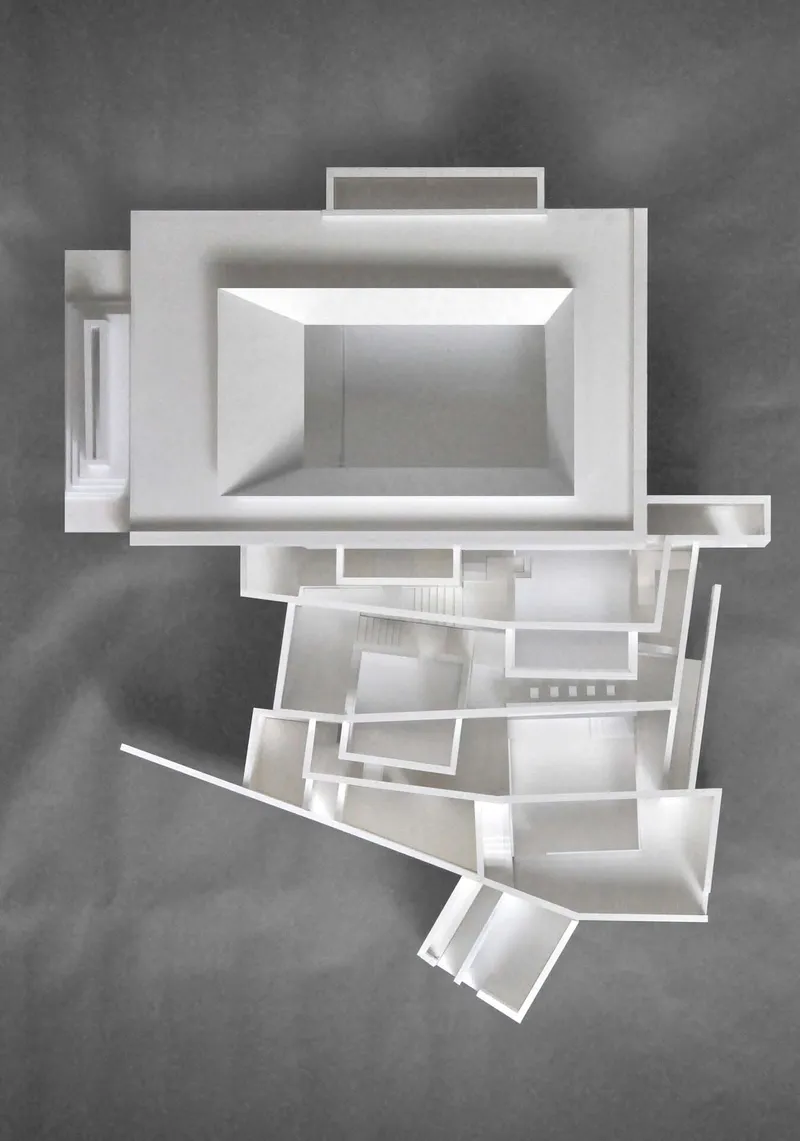 Top-down view of physical sectional model showing central courtyard and radiating angled volumes