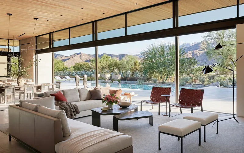 Living room with clerestory windows overlooking pool terrace and desert landscape