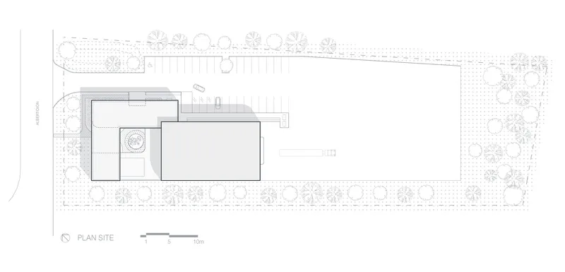 Site plan drawing showing two offset rectangular volumes surrounded by landscaping and tree placements