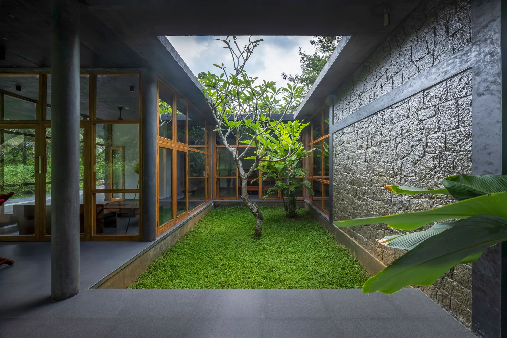 3dor Concepts Wraps a Kerala Home in Mirrored Concrete Arcs Around a Courtyard Tree