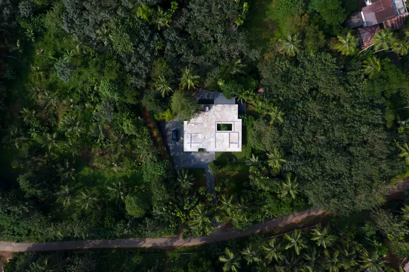 Aerial view of the compound's white roofs nestled within dense coconut palm canopy