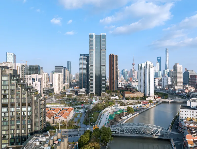 Twin towers with vertical glass and white louvered facades viewed across the waterfront in daylight