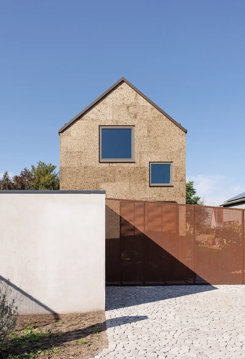 Gable facade showing two stacked windows above the white base and perforated copper screen fence