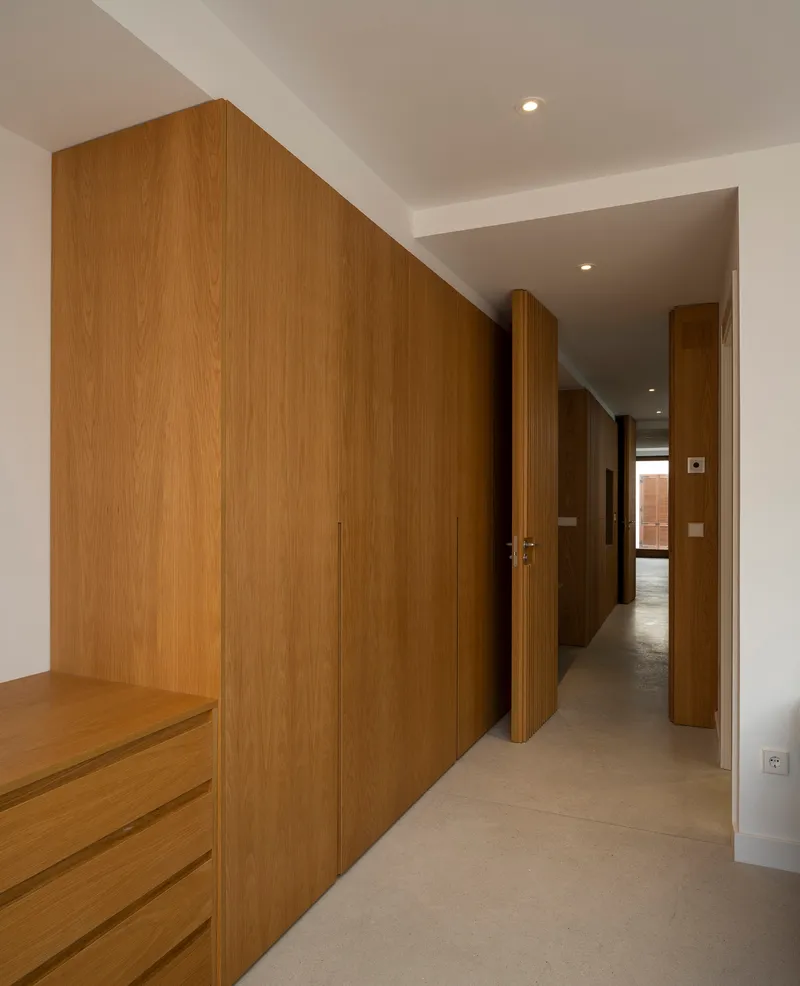 Corridor with built-in oak veneer wardrobes and ceiling recess forming a linear passage