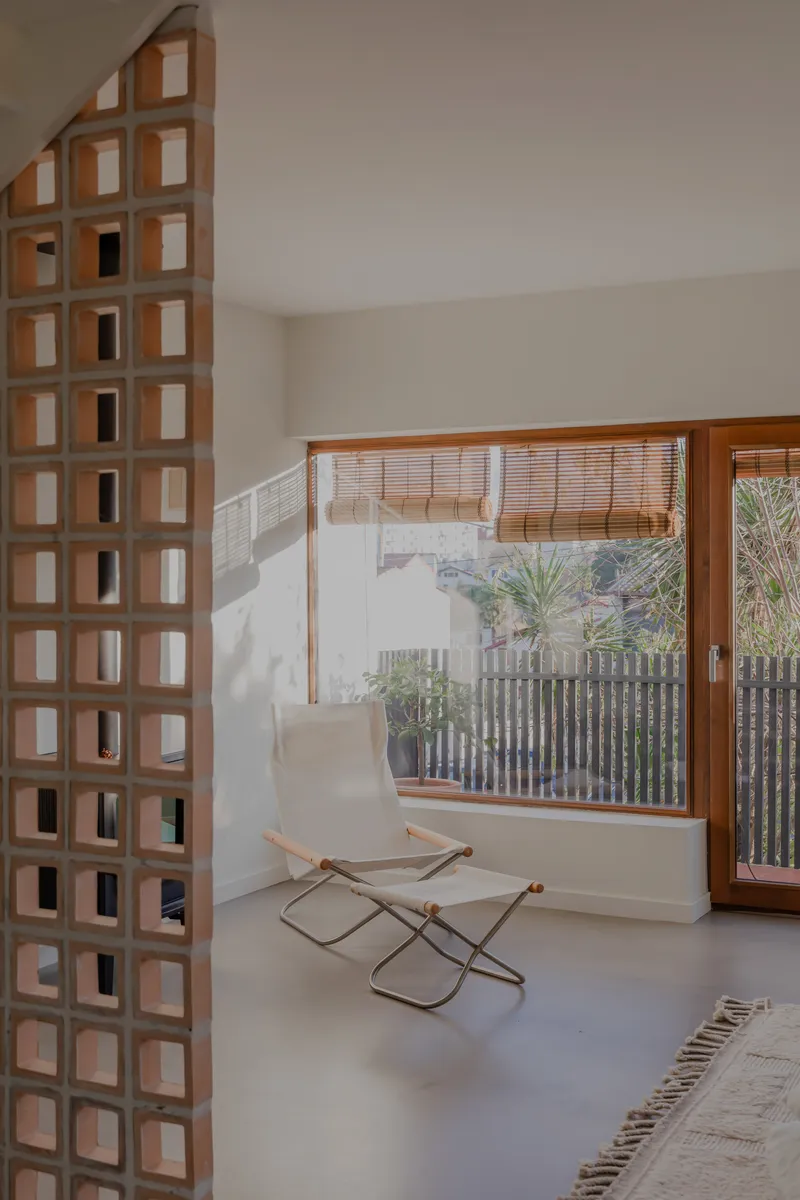 Timber gridded screen beside a window with bamboo blind overlooking a courtyard with vertical slat fencing