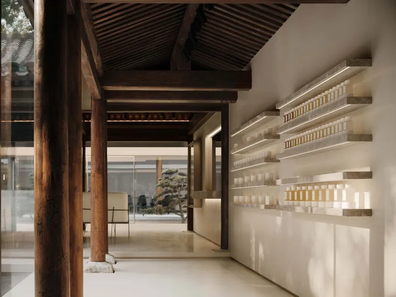 Interior with exposed timber beams and columns alongside illuminated product shelving along a white wall