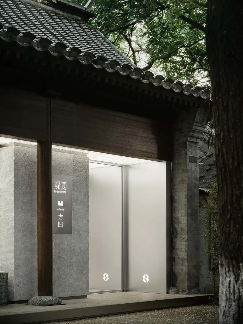 Entry facade with timber eaves and white pivot door beneath overhanging tiled roof and tree canopy