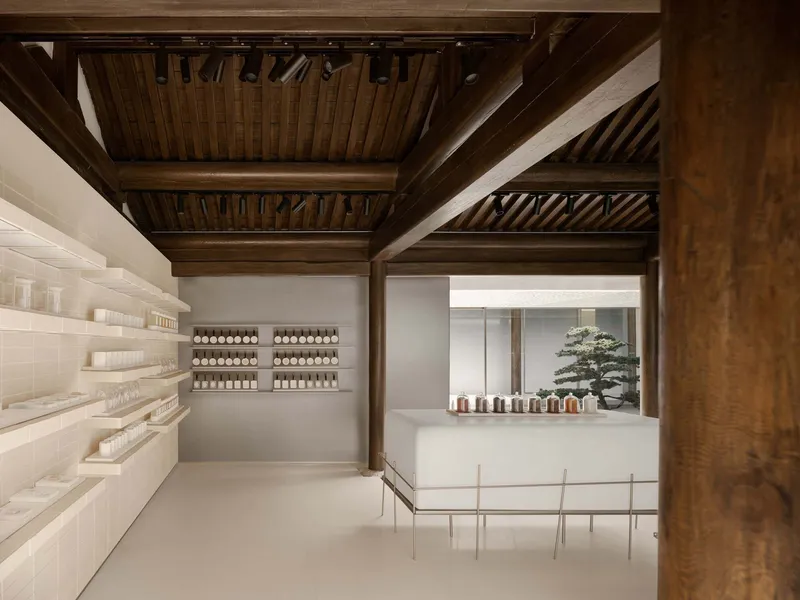 This architectural image showcases a modern retail space with a blend of traditional and minimalist design elements. The interior features a striking wooden cei