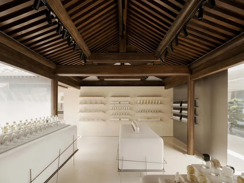 Interior retail space with exposed timber roof beams and white display shelving beneath slatted ceiling