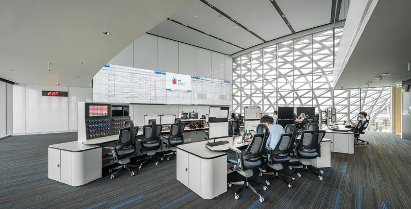 Control room interior with workstations facing diagrid glazed wall overlooking the landscape