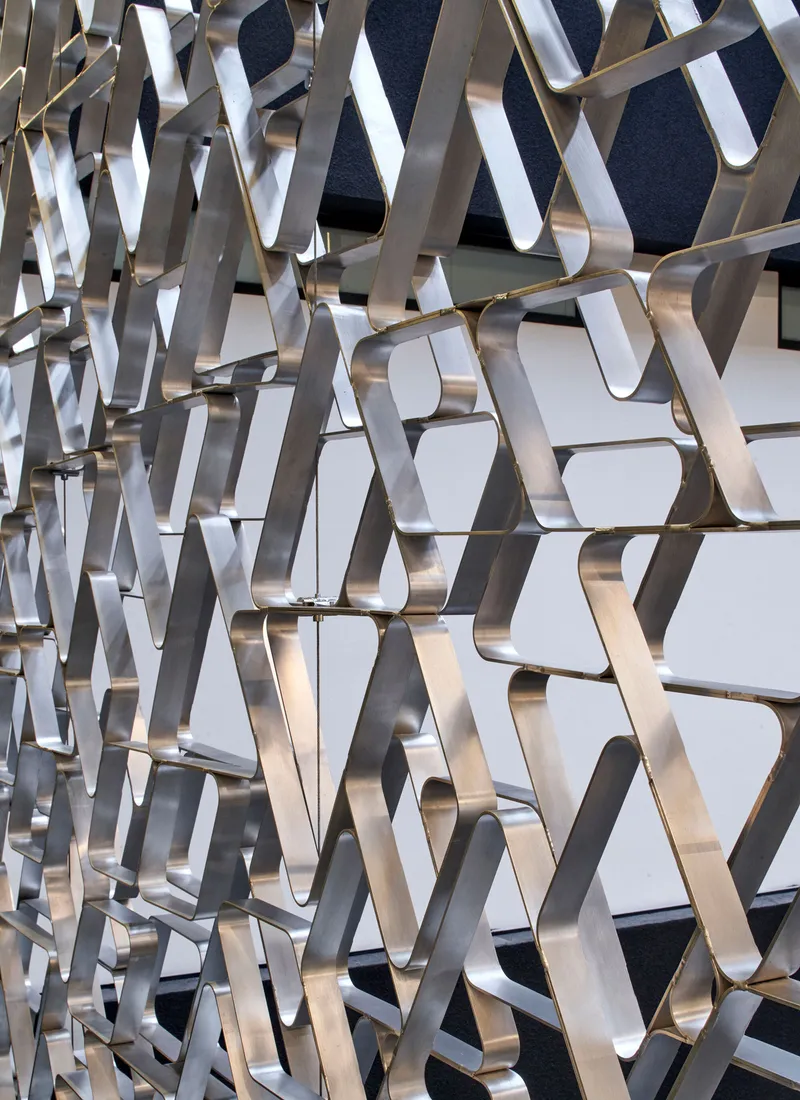 Close-up of the polished metal triangular screen surface catching daylight and shadow