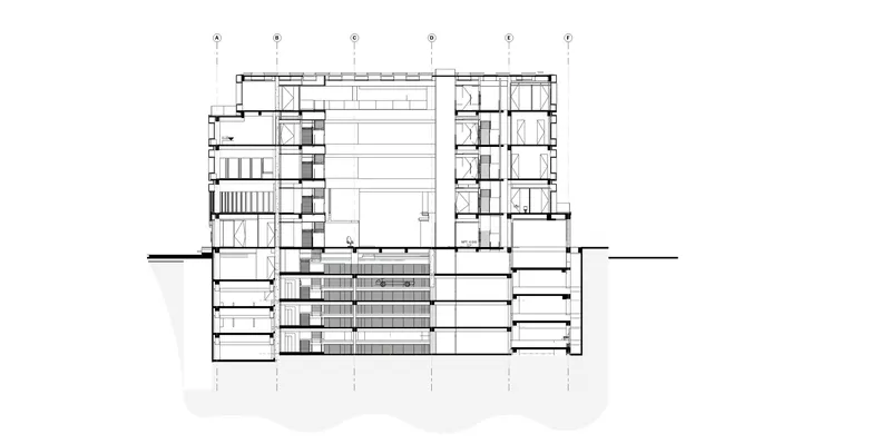 Section drawing showing a central atrium with surrounding multi-story volumes and underground levels