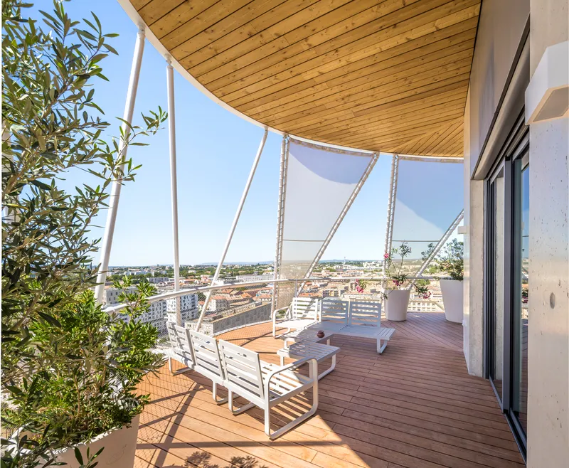 Terrace with timber decking and curved wood ceiling under white structural arms and mesh screens