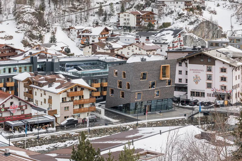 Elevated view of the shingled building set within a snow-covered alpine village