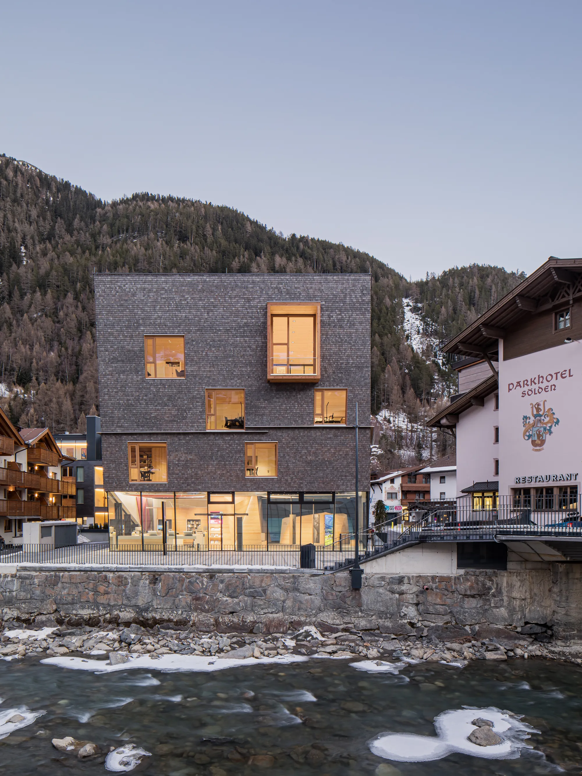 Obermoser + Partner Architekten Wrap an Alpine Tourist Center in Pre-Greyed Larch Shingles