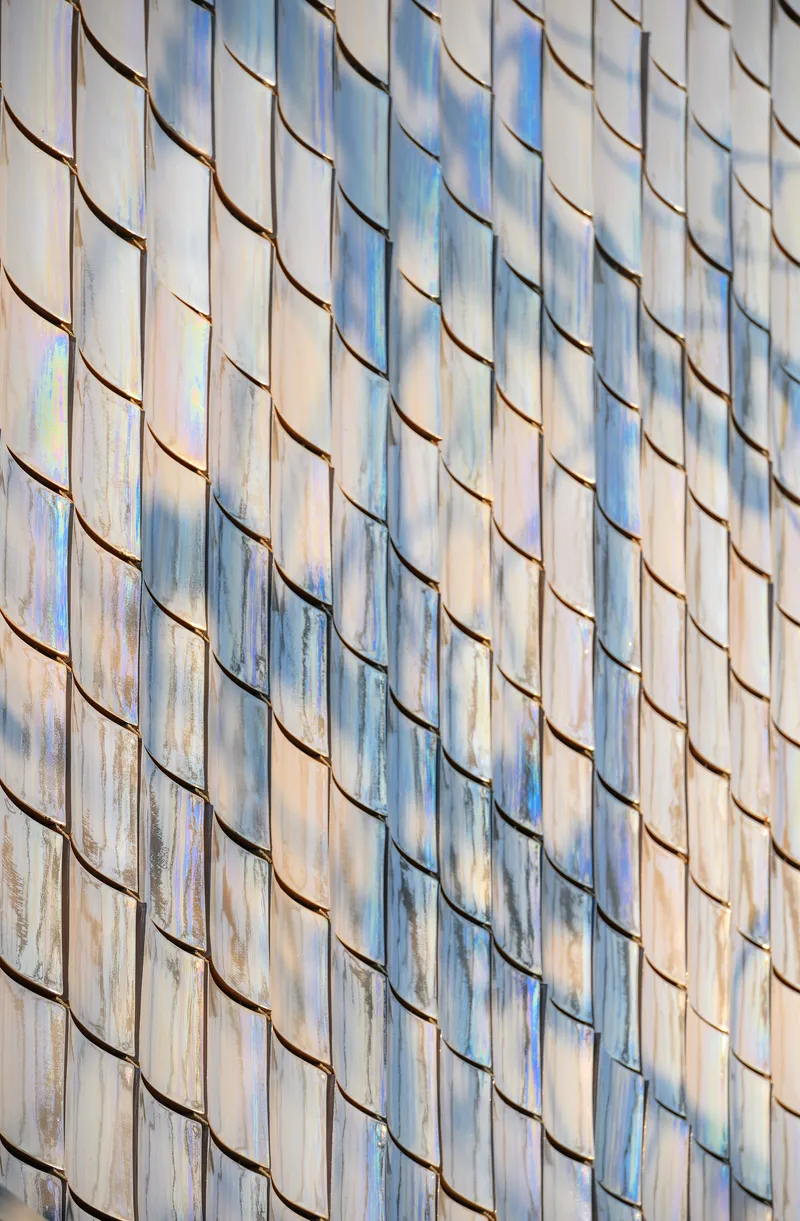 Close-up of the scalloped glass tile pattern showing weathered patina and color variation