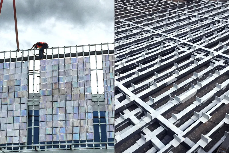 Worker installing iridescent tile panels on the gridded metal framework under cloudy skies