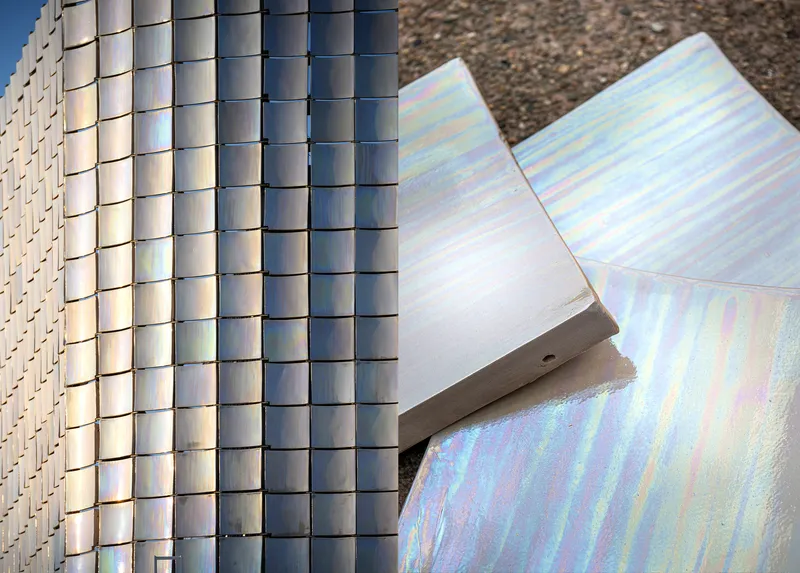 Detail of curved iridescent panels meeting cylindrical metal tile cladding in daylight