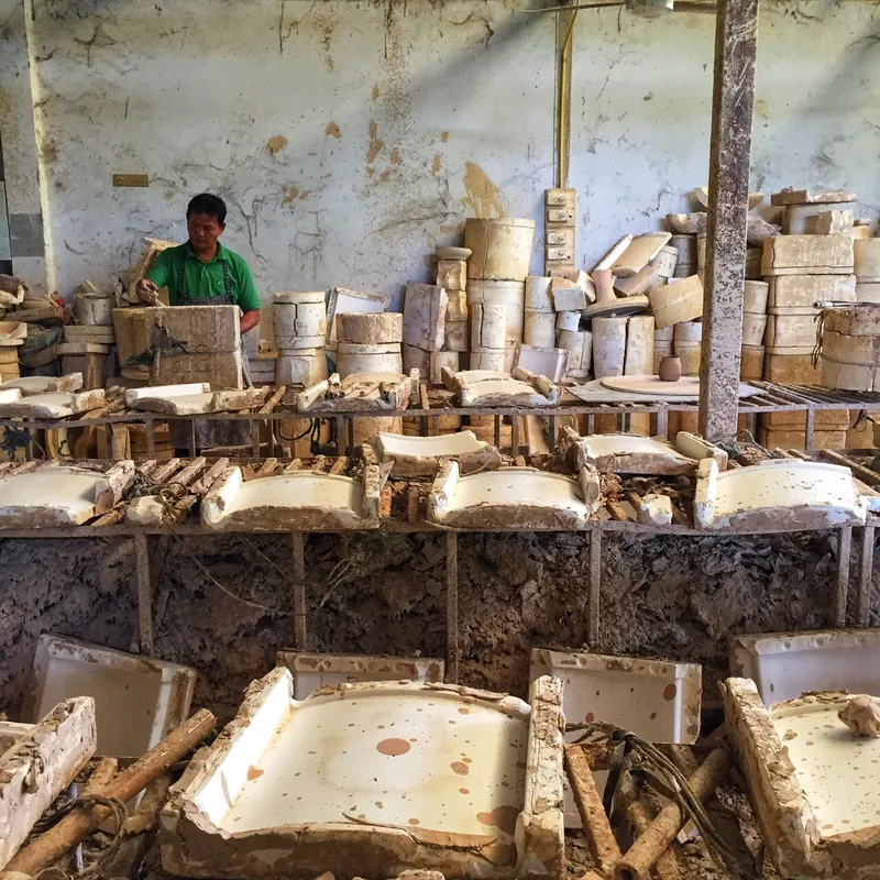 Rows of ceramic molds stacked on wooden racks in the production room