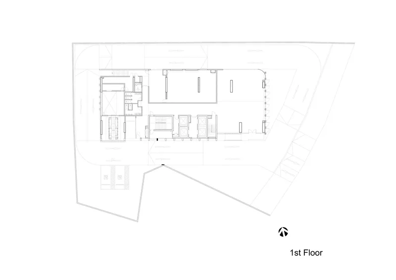 First floor plan drawing showing an irregular trapezoidal site with large open spaces and service cores