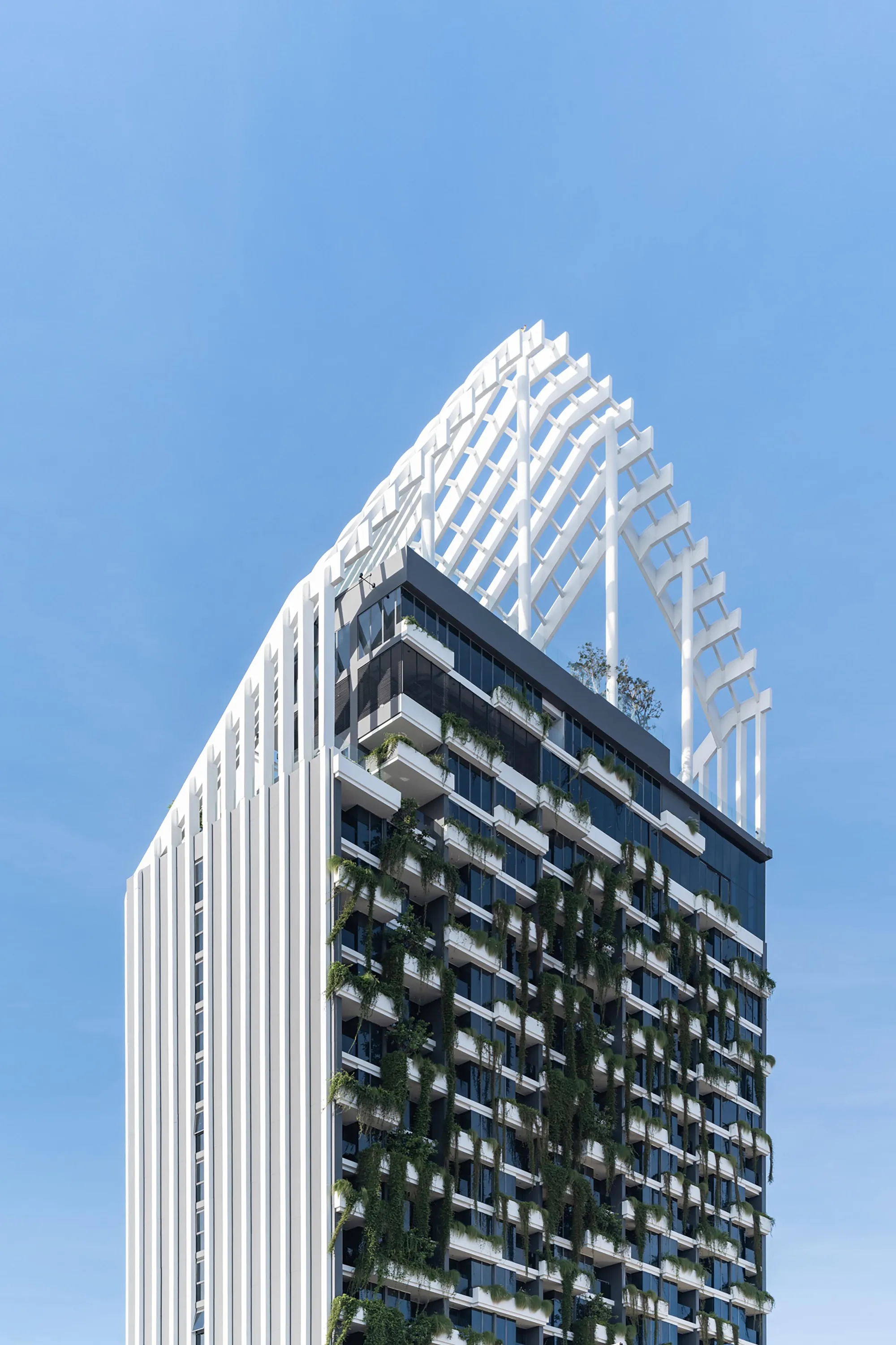 Architects 49 Wraps a 23-Story Pattaya Tower in Vertical Fins and Living Greenery