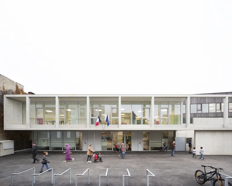 Street-facing elevation showing two-storey glazed volume with white frame and children in motion