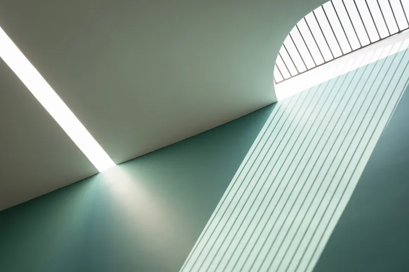 Skylight view showing sloped ceiling planes and vertical slatted screen in pale blue