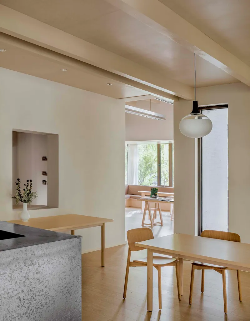 Dining area with terrazzo counter and pendant lamp looking through a doorway to a reading nook