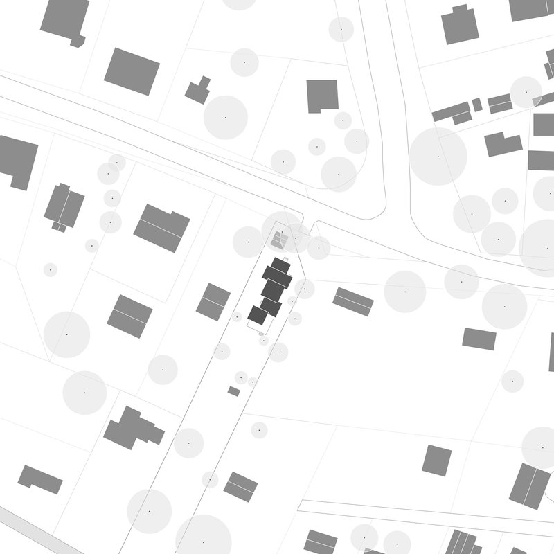 Site plan drawing depicting building footprints and tree canopies along a diagonal street