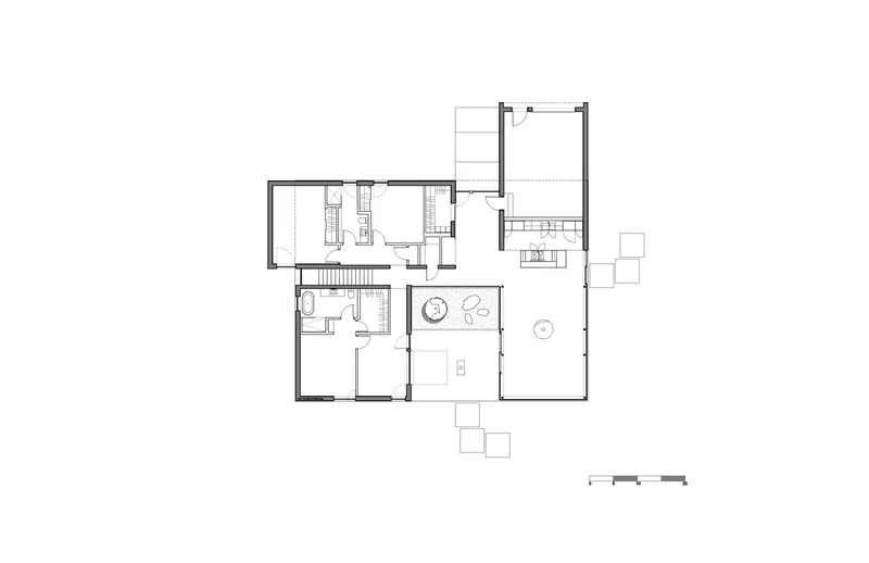 Floor plan drawing showing an L-shaped layout with bathrooms, kitchen and open living spaces