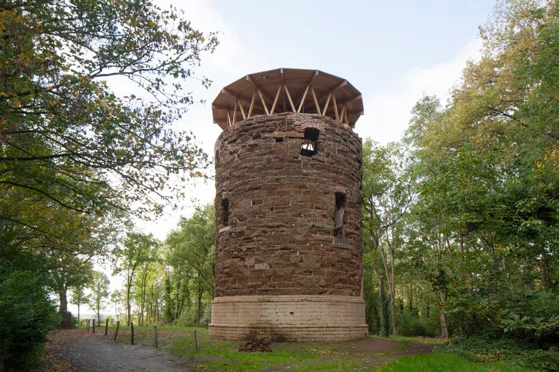 Front elevation of the restored brick tower with new timber crown in autumn woodland