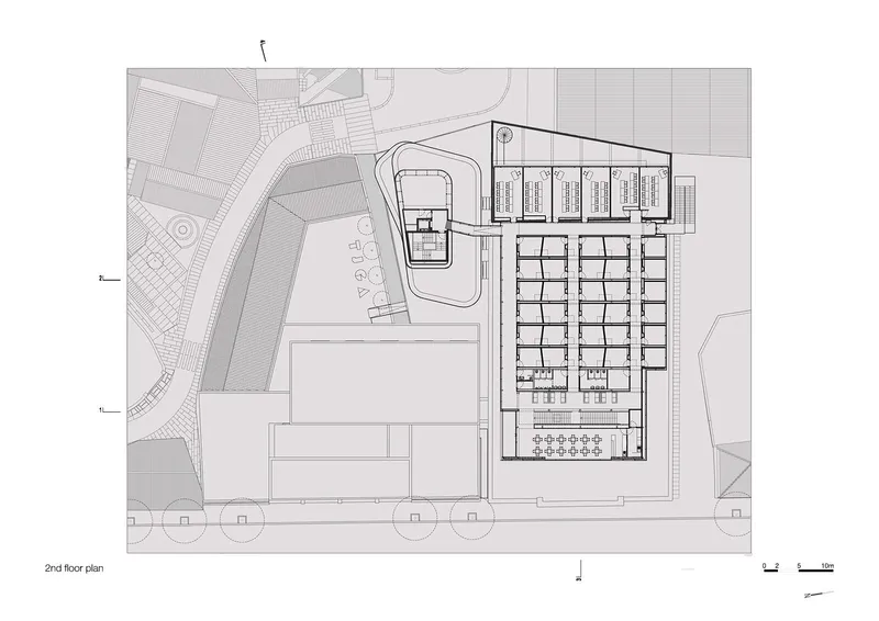 Second floor plan drawing displaying grid of rooms along one wing and smaller pavilion with curved courtyard