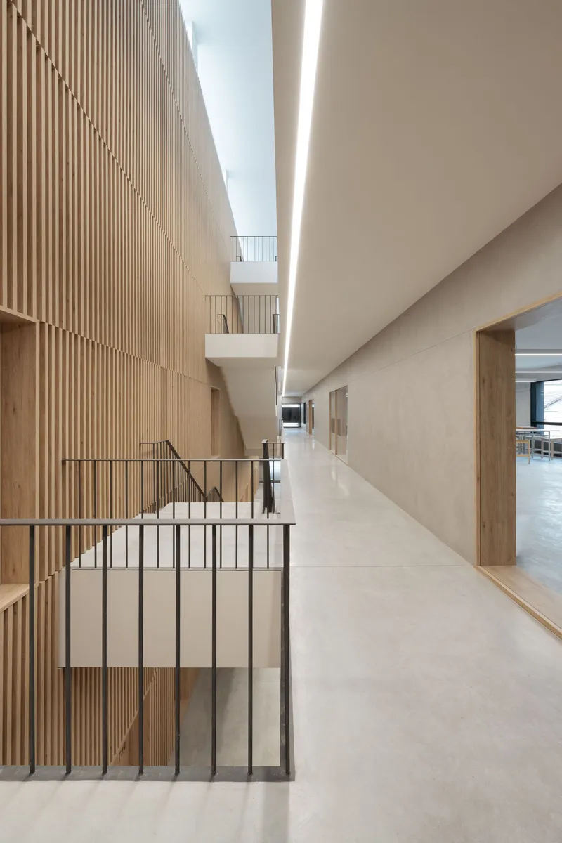 Interior corridor with vertical timber slat wall and linear skylight above the stairwell