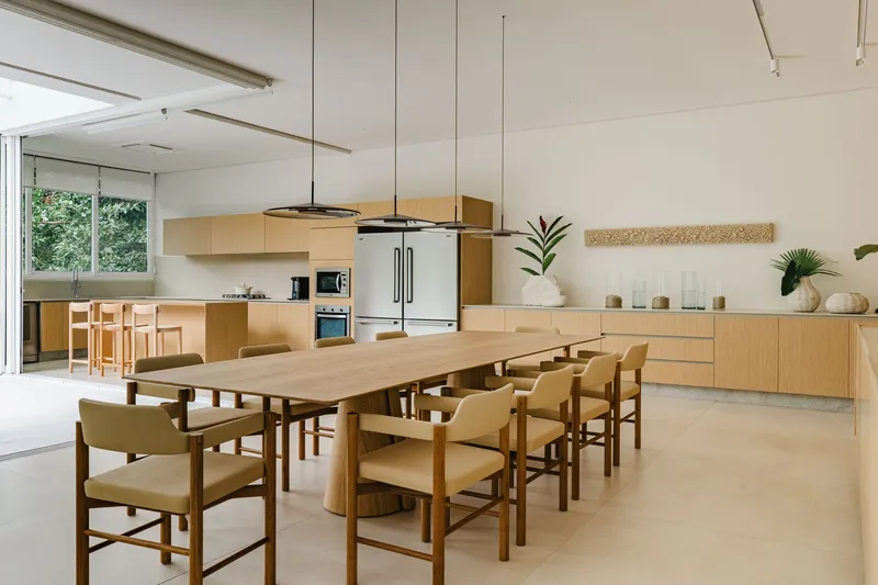 Open kitchen and dining area with timber cabinetry and suspended circular pendant light fixture