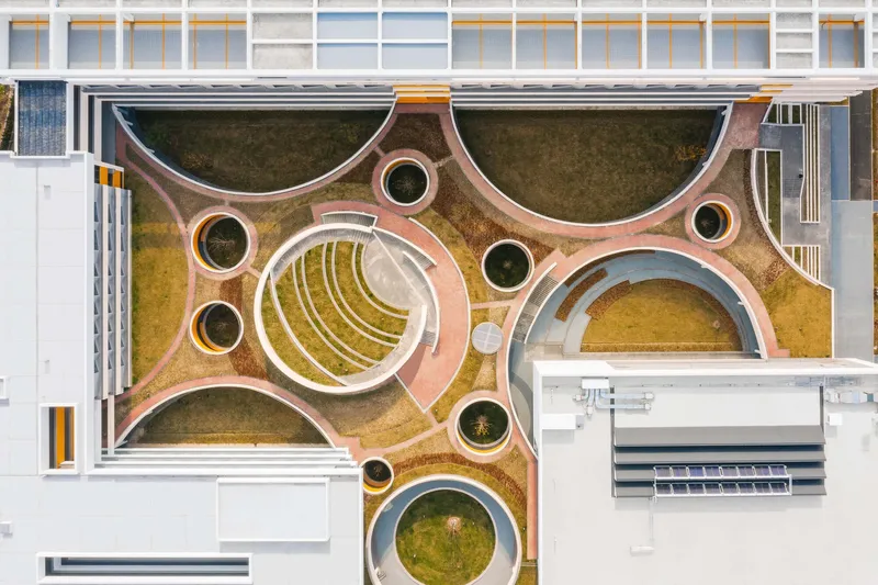 Aerial view of the courtyard roof garden with circular and terraced planters framed by residential wings