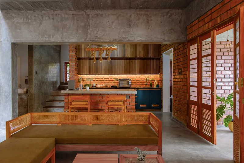 Open plan living area with exposed brick walls, concrete ceiling, and timber louvered doors