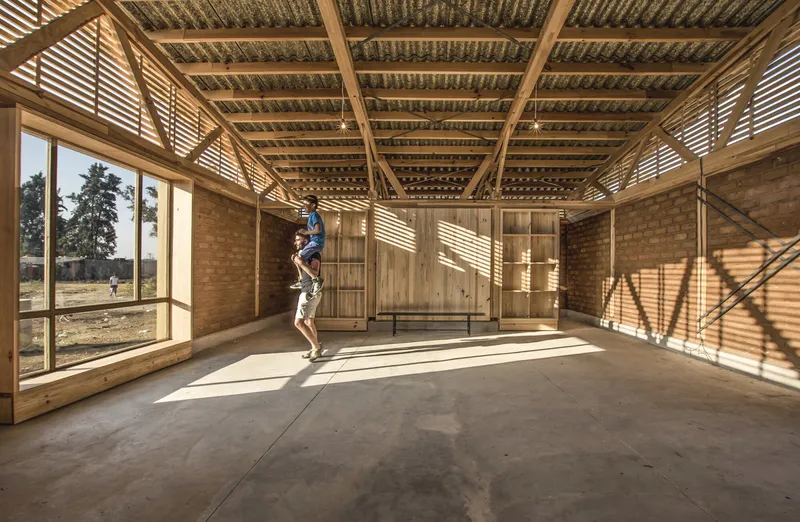 Interior room with timber framed walls and woven bamboo ceiling casting dappled afternoon shadows