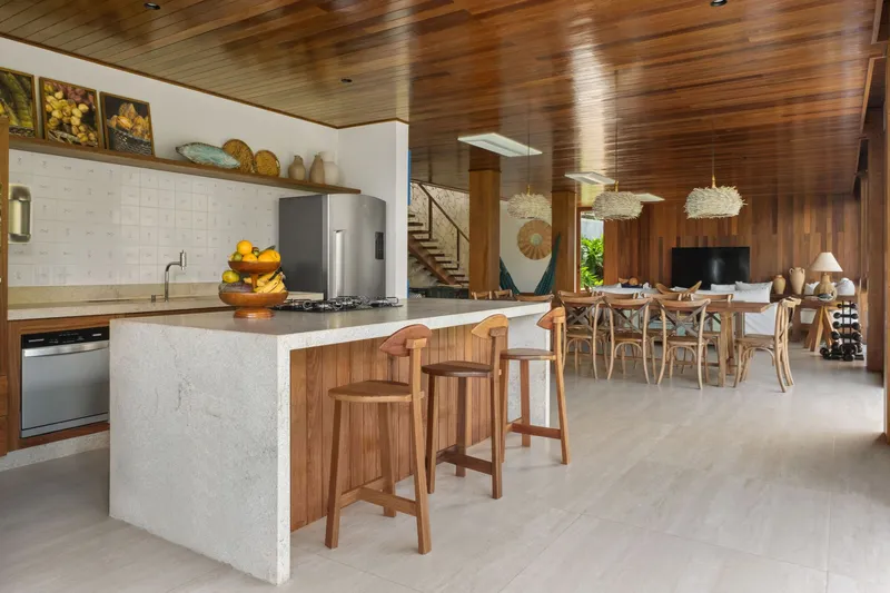 Open kitchen and dining room with terrazzo island and slatted timber ceiling panels