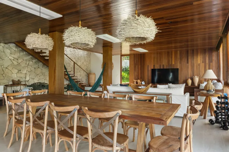 Open living and dining space with timber ceiling, textured pendant lights and a hammock near the staircase