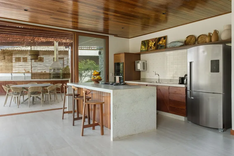 Kitchen island with terrazzo countertop and timber cabinetry overlooking an outdoor dining terrace