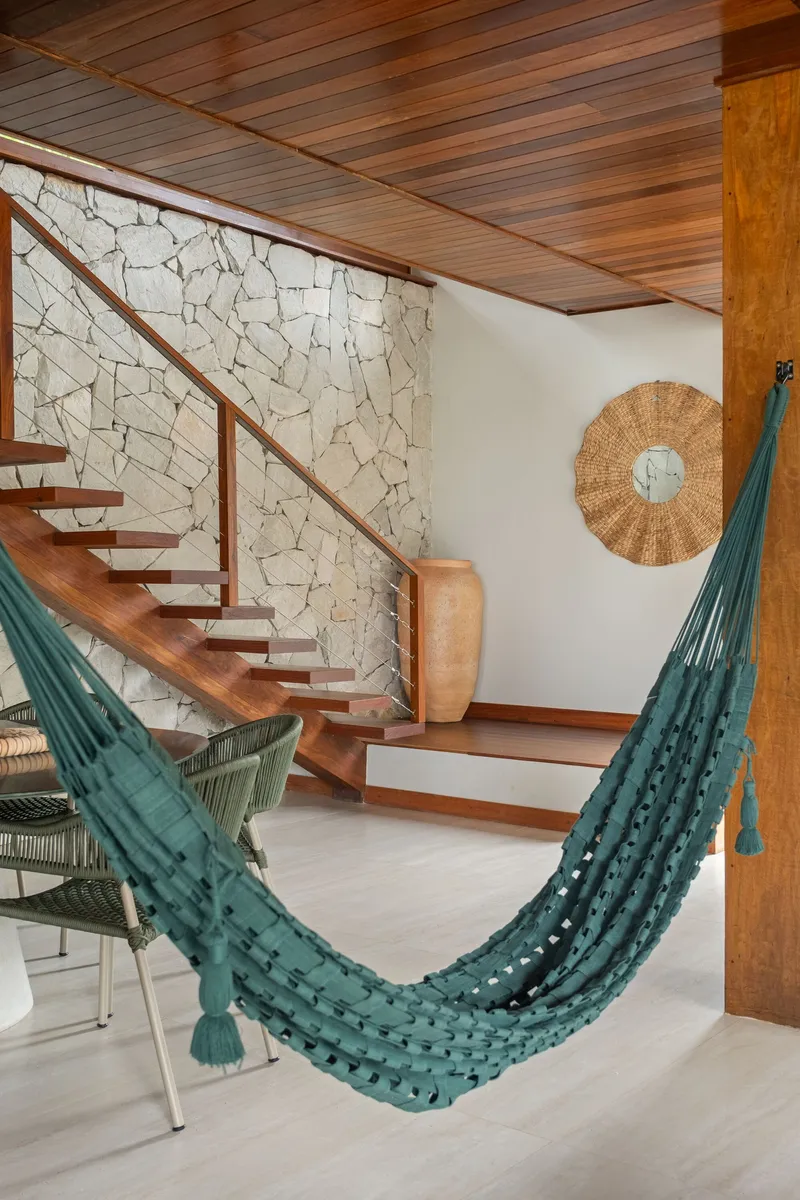 Timber staircase with open treads ascending along a mortared stone accent wall