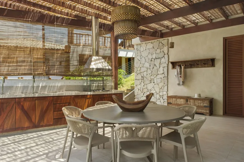 Dining area with woven bamboo ceiling and dappled sunlight filtering through the pergola