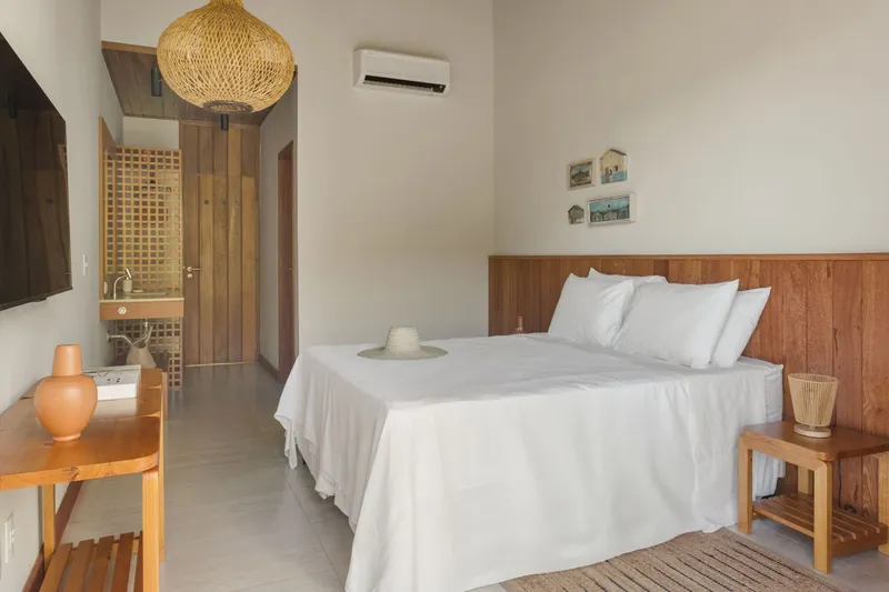 Bedroom with timber wainscoting and view through doorway to latticed screen beyond