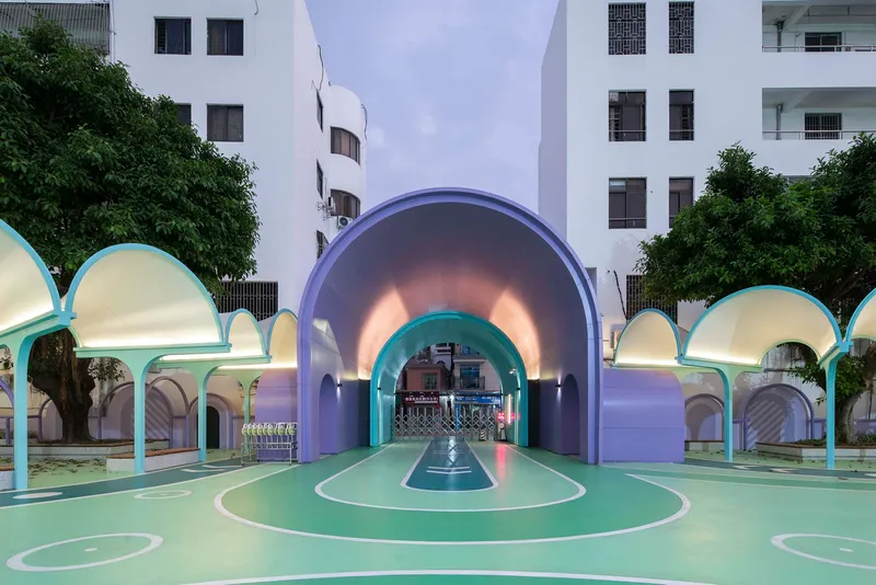 Illuminated purple arched portal framing the entry gate at dusk between rows of white dome canopies