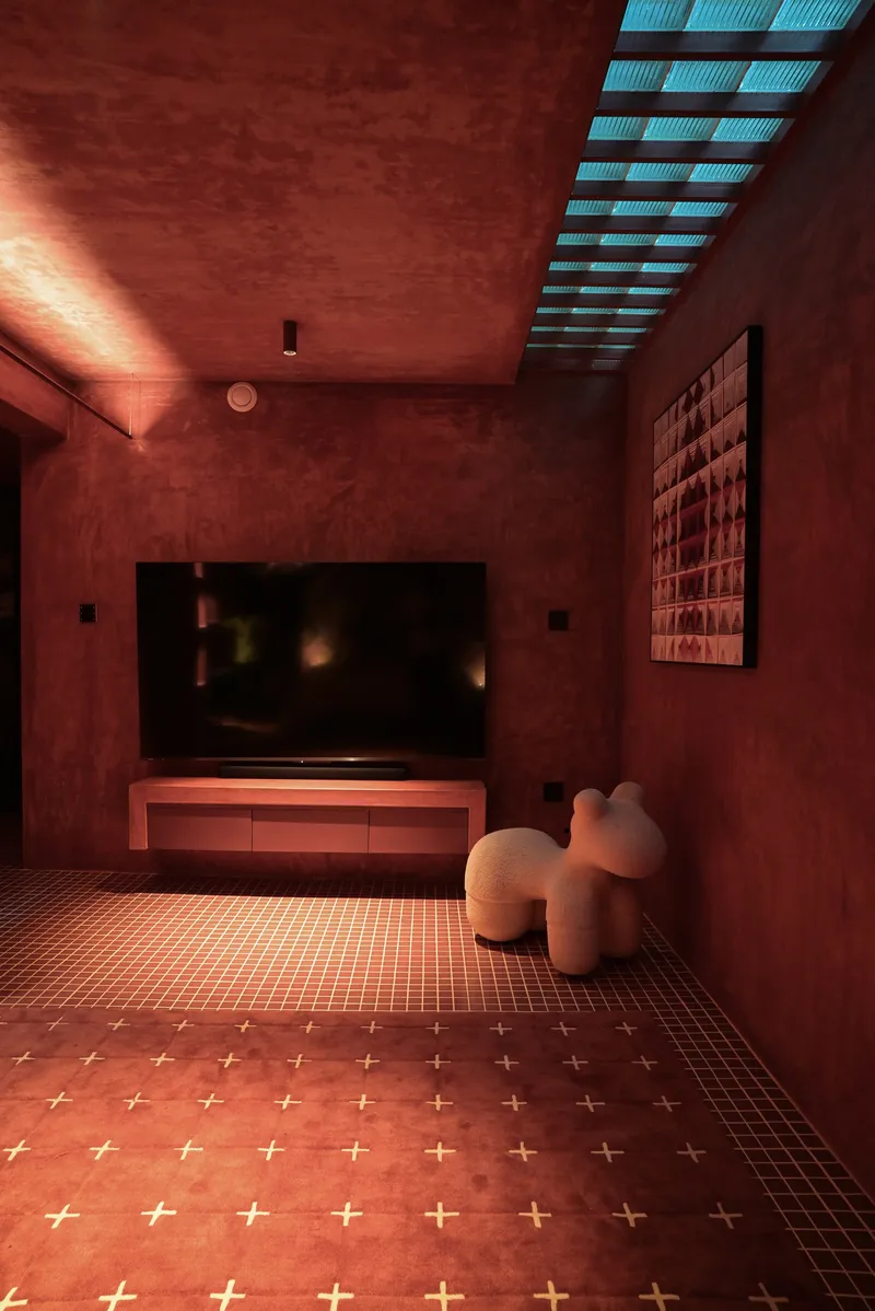 Media room with glass-slat ceiling opening and cross-inlay tile floor in red plaster finish