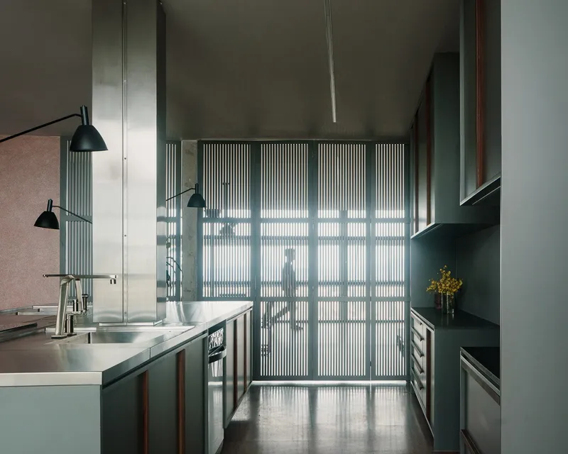 Fluted glass partition casting striped shadows across the polished concrete floor